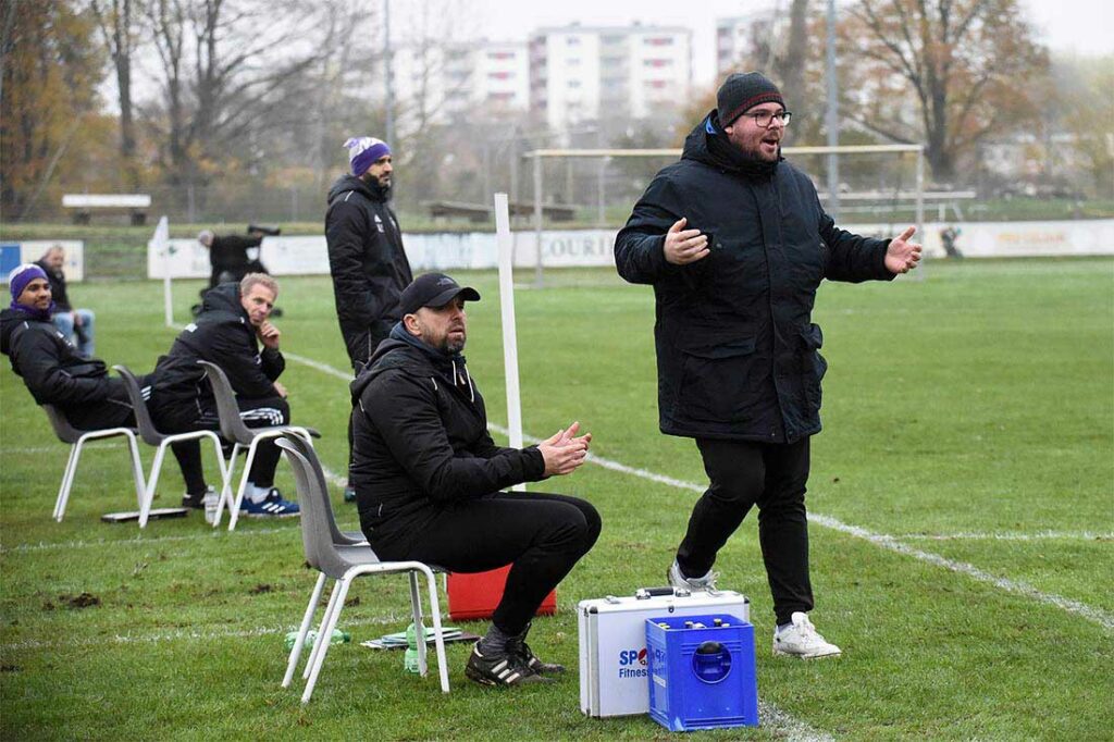 Das VfR-Trainerteam (im Hintergrund) genießt seelenruhig die Partie. Thilo Becker (re.) und sein Co Nicko Glashoff sind fassungslos. © 2022 Olaf Wegerich