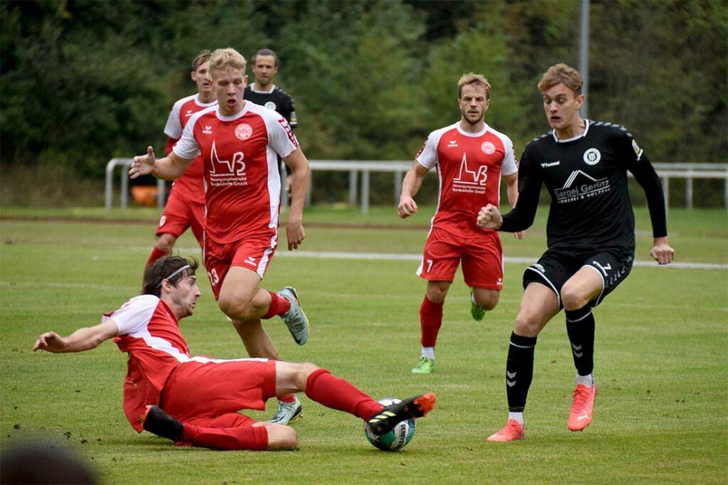 Yannick Ostermann (Bordesholm) ist mit einer Grätscche vor Nils Krampe (Pansdorf) am Ball. Quelle Olaf Wegerich