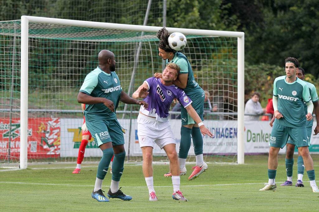 Ayoub Assameur (PSV Neumünster) überspringt beim Kopfball Nils Drauschke (VfR Neumünster). Links Grady Zinkondo. © 2026 Ismail Yesilyurt