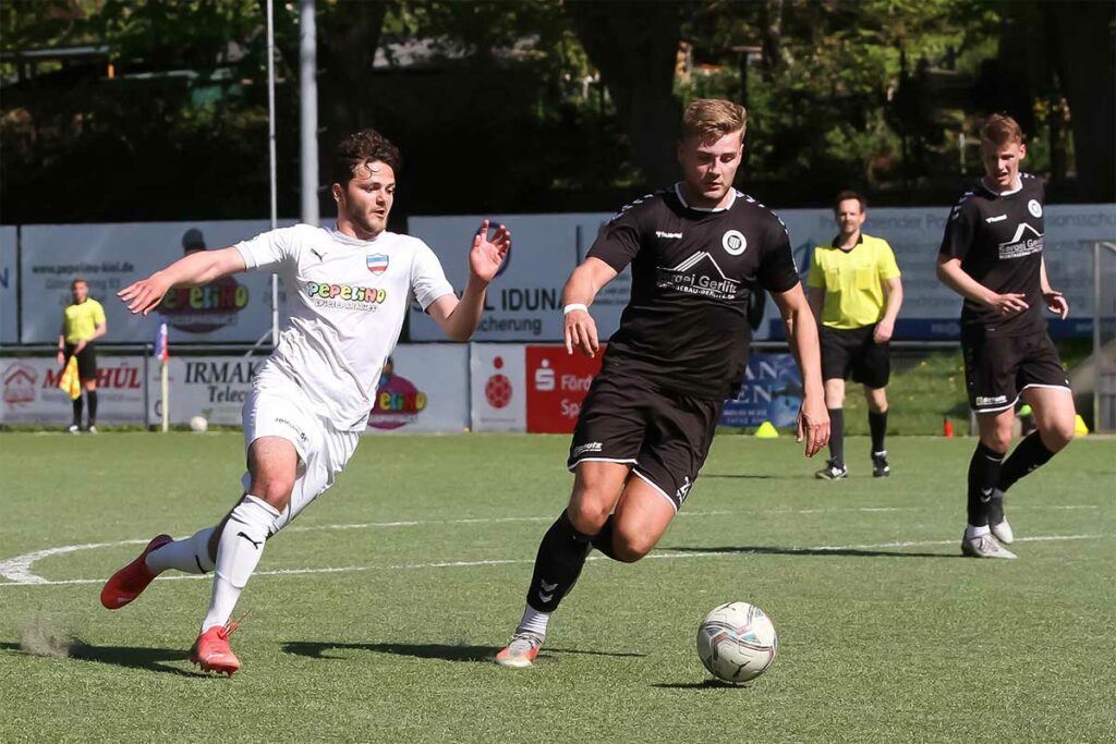 Serkan Yildirimer (li., Inter Türkspor) sucht im Strafraum den Abschluss, doch Paul Manthe (TSV Pansdorf) ist gleich mit der Fußspitze eher dran.