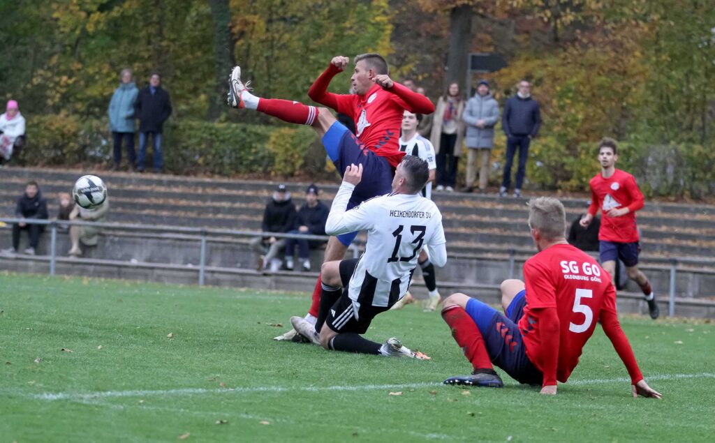 Wilhelm Gradert (SG Oldenburg-Göhl), hier im Spiel beim Heikendorfer SV von Dennis Lühr (13) attackiert, ist für das 1:1 gegen die SG Eckernförde-F. © 2024 Ismail Yesilyurt