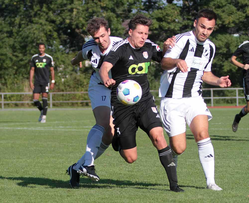 Die eingewechselten Gösta Zantopp (Heikendorfer SV) und Nico Heinrich (re.) gegen Dänischenhagens besten Torschützen Tim Ladewig. © 2024 Ismail Yesilyurt