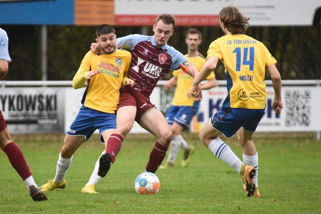 Finn Lorenzen (SC Weiche Flensburg 08 II) hat die Szene gegen Nikos Wolf (li., SV Todesfelde) im wahrsten Sinn des Wortes im Griff. © 2022 Olaf Wegerich