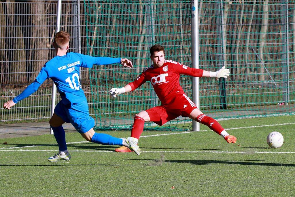 Justin Petersen (Inter Türkspor Kiel II) bereitet gerade das 2:0 vor. MTV-Keeper Marc-Phililip Ross kann das nicht verhindern. © 2023 Ismail Yesilyurt
