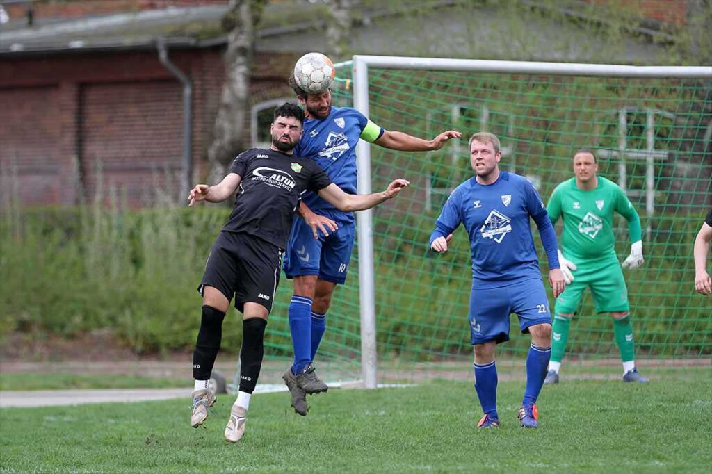 Bei hohen Bällen in den Plöner Strafraum hatte der TSV Plön Vorteile. Wie hier Sören Balk gegen Halil Karakaya (MED SV). © 2025 Ismail Yesilyurt