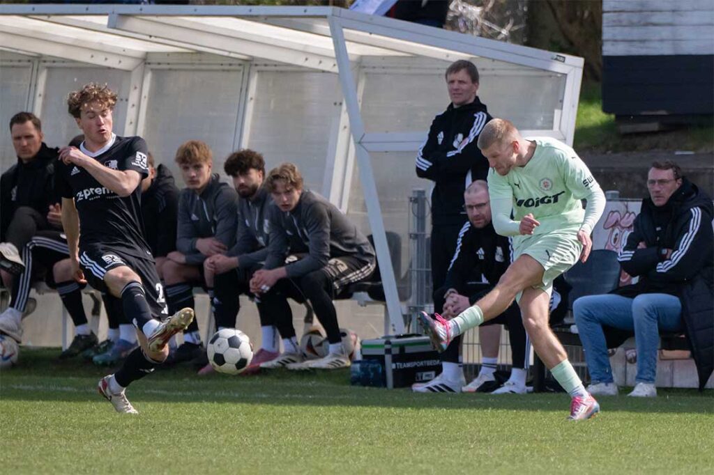 Nils Drauschke (PSV Neumünster) gegen Thede Reimers (li., Heider SV) vor der Heider Trainerbank. © 2026 Volker Schlichting.