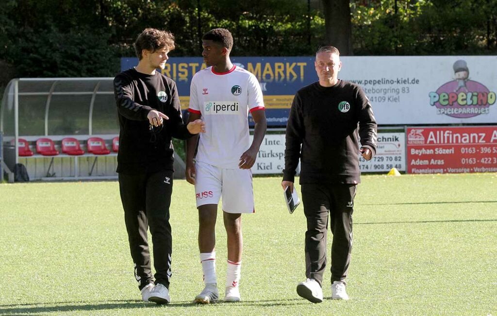 Chefcoach Dominik Toschka erklärt Omorogbe Odiase (VfB Lübeck II) wie er sich das VfB-Spiel vorstellt. Rechts Co Arne Krinke-Myers. © 2023 Ismail Yesilyurt