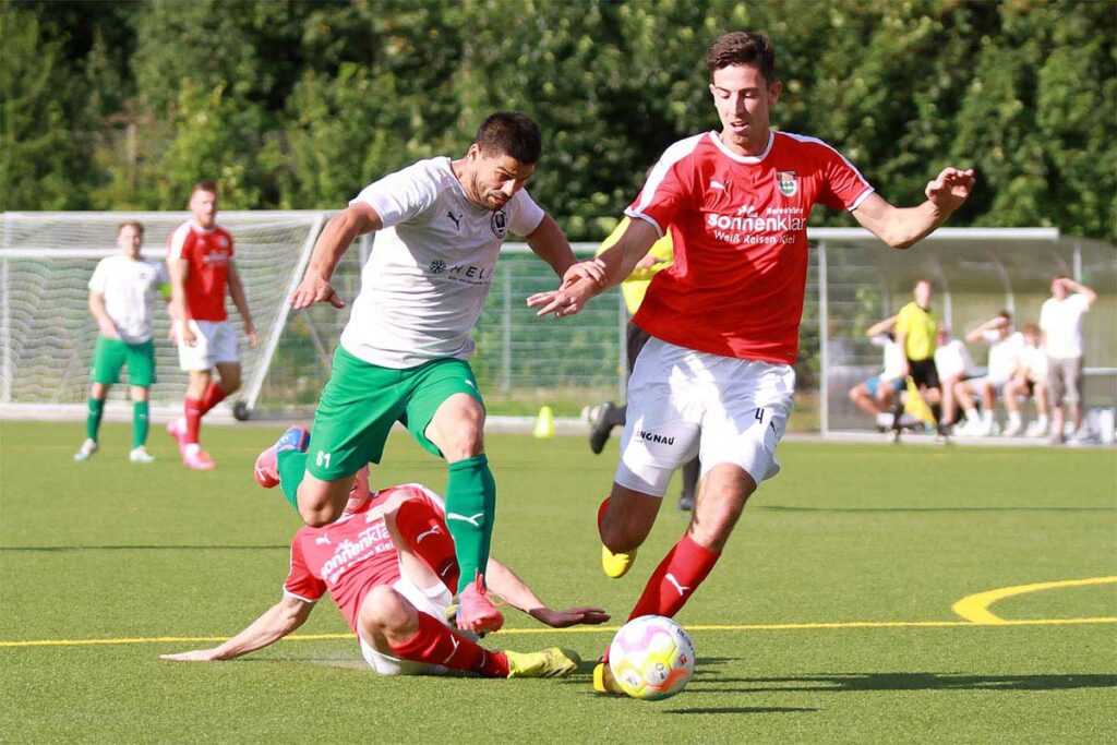 Die erste Hürde mit Florian Krege (TSV Kronshagen) genommen, nutzt Driton Gashi (TSV Klausdorf) gleich das gestreckte Bein von Silas Barho (re.) als Absprungbrett für einen Foulelfmeter. Quelle: Ismail Yesilyurt