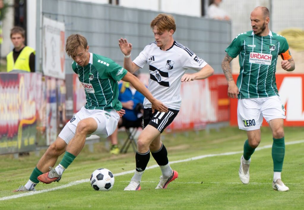 Henry Jeschonek (VfB Lübeck) im Duell mit Mathis Harms (Heider SV) Rechts Marvin Thiel. © 2026 Volker Schlichting Henry Jeschonek (VfB Lübeck) im Duell mit Mathis Harms (Heider SV) Rechts Marvin Thiel. © 2026 Volker Schlichting