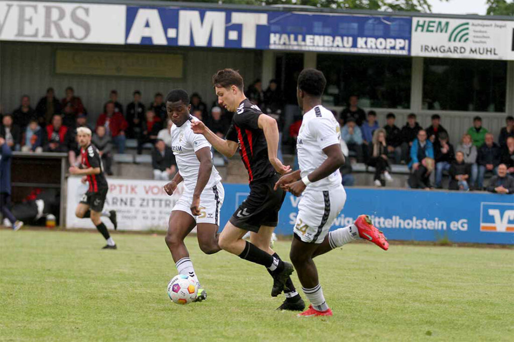 Thies Bütow (TSV Kropp) versucht, Amoah Hartwig (li.) und Oba Akomedi (1. FC Phönix Lübeck II) zu entwischen. © 2025 Ismail Yesilyurt Thies Bütow (TSV Kropp) versucht, Amoah Hartwig (li.) und Oba Akomedi (1. FC Phönix Lübeck II) zu entwischen